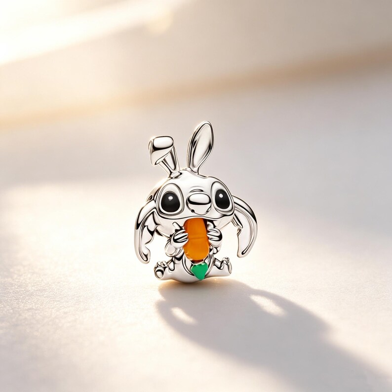 Puede incluir: Un charm de color plateado con forma de personaje de dibujos animados, que se asemeja a un conejo, sosteniendo una zanahoria naranja. El charm tiene grandes ojos negros y un detalle en forma de coraz&oacute;n verde. El charm mide unos 2,5 cm de alto.