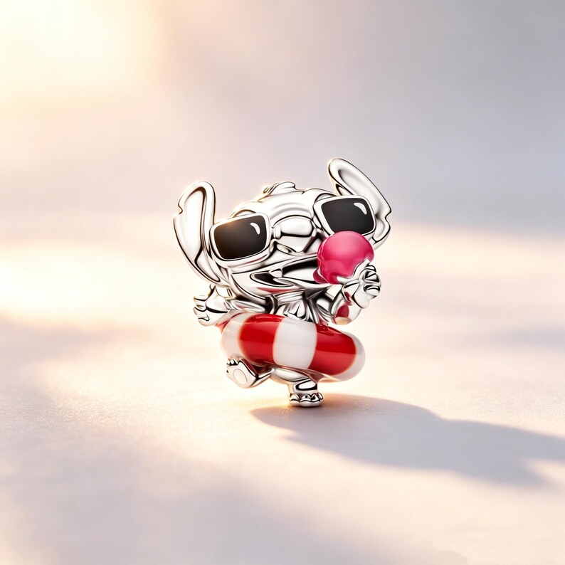 Puede incluir: Un charm de plata que representa a un personaje de dibujos animados con gafas de sol y un flotador a rayas rojas y blancas. El personaje tambi&eacute;n sostiene una bola rosa. El charm es muy detallado y tiene un acabado pulido.