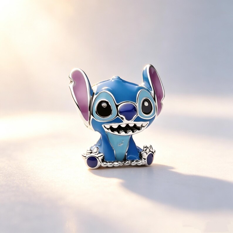 Puede incluir: Una figura azul y plateada del personaje Stitch de la pel&iacute;cula de Disney Lilo & Stitch. La figura tiene orejas grandes con el interior rosa, una amplia sonrisa y ojos negros grandes. La figura est&aacute; sentada.
