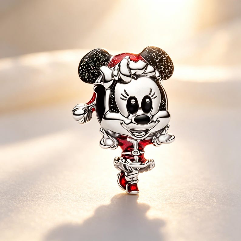 Puede incluir: Un charm de plata con un personaje de dibujos animados con un atuendo festivo. El charm tiene un gorro de Pap&aacute; Noel rojo y blanco, un vestido rojo y orejas negras con motas blancas. El personaje sonr&iacute;e y tiene ojos negros y nariz negra.