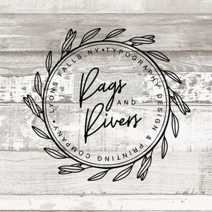 May include: Black and white logo design with a wreath of leaves around the text "Rags and Rivers Printing & Typography Design" with the location "Lyons Falls, NY" underneath.