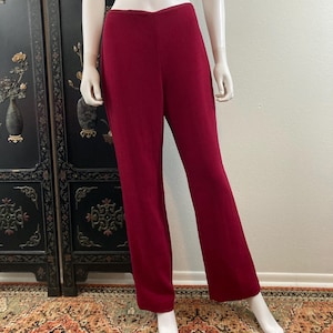 May include: A pair of wide-leg pants in a deep burgundy red color. The pants have a straight leg and a high waist.