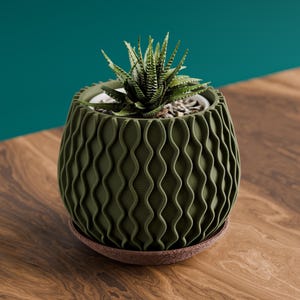 Maceta decorativa Hertz con diseño ondulado y base de goteo.