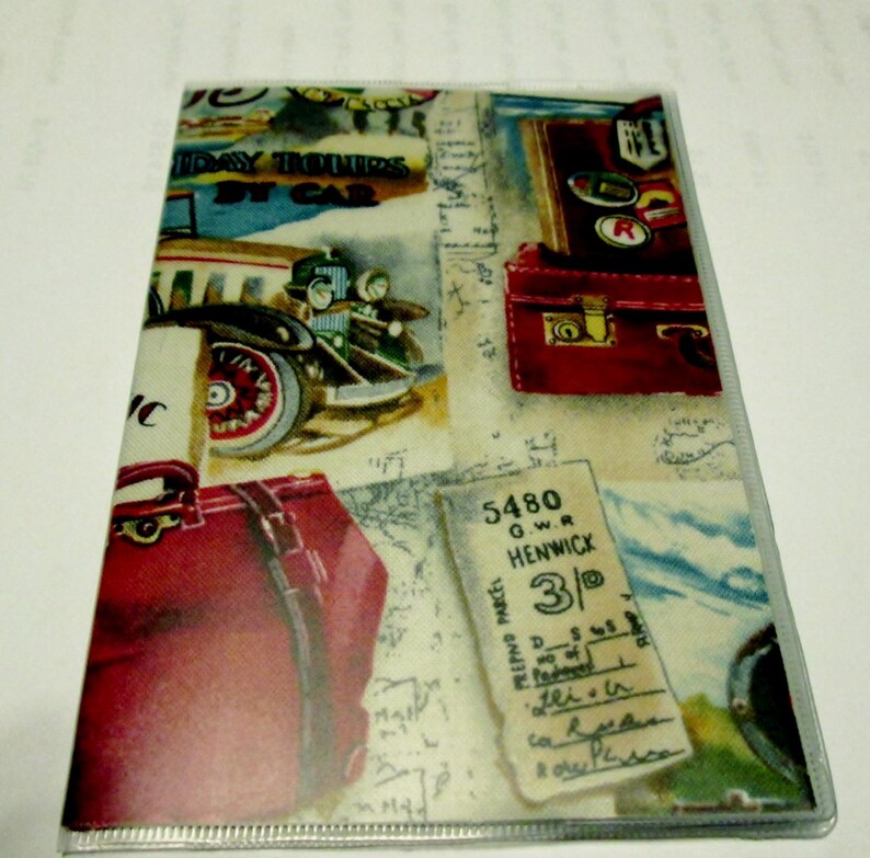 May include: A vintage travel themed passport holder with a red suitcase, a vintage car, and a train ticket that reads "5480 G.W.R. HENWICK 3/-".