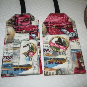 May include: Two luggage tags with a vintage travel theme. The tags are made of fabric and feature a red suitcase, a plane, and a map. The text on the tags reads "Holiday Tours by Car" and "Across the World".