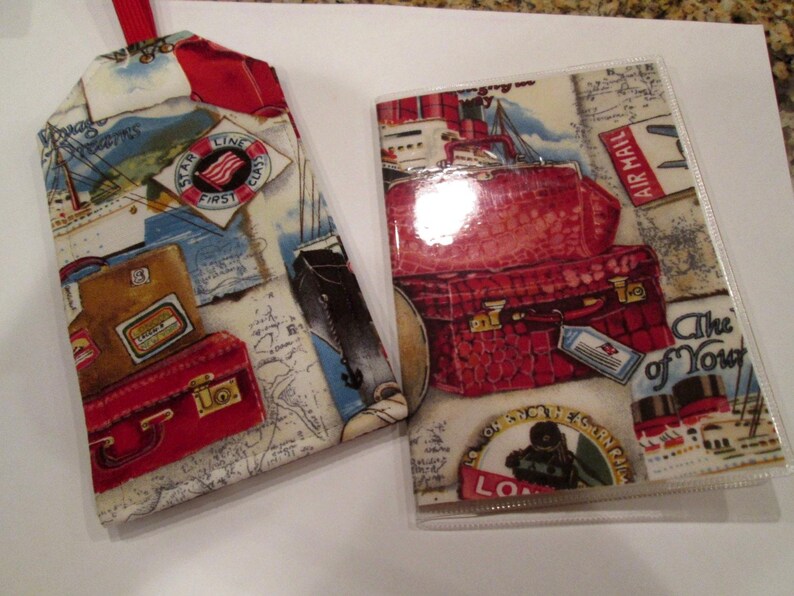 May include: Two fabric passport holders with a travel theme. The larger holder has a red, white, and blue star with the words "Star Line First Class" and "The of Your" printed on it. The smaller holder has a red, white, and blue star with the words "Star Line First Class" printed on it.