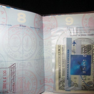 May include: A passport with a blue and white American Express card and a US dollar bill inside a clear plastic pocket. The passport has a stamp from the Dominican Republic dated October 23, 2002.