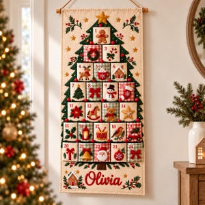 May include: A vertical fabric advent calendar featuring a green Christmas tree design with twenty-four numbered pockets. Each pocket displays embroidered holiday icons like a gingerbread man, snowman, and Santa. The name Olivia is stitched in red.