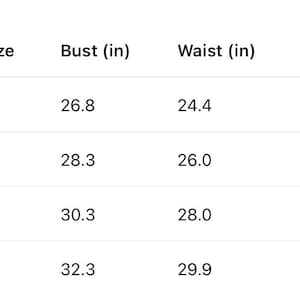 K&ouml;nnte beinhalten: Eine schwarz-wei&szlig;e Gr&ouml;&szlig;entabelle mit Kleidungsma&szlig;en in Zoll. Die Spalten umfassen Size, US Size, Bust (in), Waist (in) und Length (in). Die Zeilen zeigen spezifische numerische Werte f&uuml;r die Gr&ouml;&szlig;en S, M, L und XL von 2 bis 14 an.