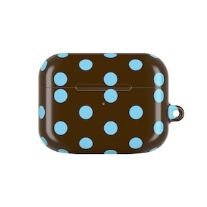 May include: A brown case with a light blue polka dot pattern. The case is rectangular with rounded edges and a small loop on the side. The case is designed to hold small electronic devices.