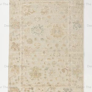 Puede incluir: Alfombra rectangular beige con un dise&ntilde;o floral desgastado y bordes deshilachados. La alfombra presenta un dise&ntilde;o central enmarcado por un borde, con tonos verdes y marrones apagados.
