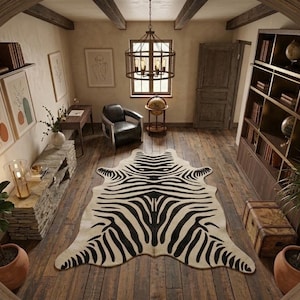 May include: A room interior with a zebra-patterned rug on a wooden floor. The space includes a leather armchair, a bookcase, and a decorative globe. A chandelier hangs from the ceiling, and artwork is displayed on the walls.