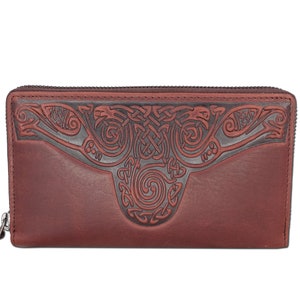 Może przedstawiać: Brązowy skórzany portfel z zamkiem błyskawicznym i ozdobnym, wytłoczonym wzorem celtyckiego węzła na przodzie.