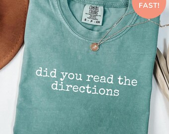 Könnte beinhalten: Ein meergrünes Kurzarm-T-Shirt mit Rundhalsausschnitt und dem weißen Text did you read the directions auf der Vorderseite. Das T-Shirt hat ein Comfort Colors Markenetikett am Innenhals und wird mit einer silbernen Anhängerkette kombiniert.