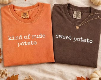Könnte beinhalten: Zwei kurzärmelige T-Shirts mit Rundhalsausschnitt. Das linke T-Shirt ist orange mit dem weißen Text kind of rude potato. Das rechte T-Shirt ist dunkelbraun mit dem weißen Text sweet potato. Beide T-Shirts haben ein Comfort Colors Markenetikett.
