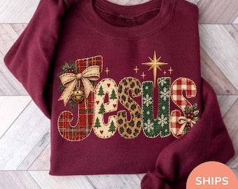 Könnte beinhalten: Ein kastanienbraunes Langarm-Sweatshirt mit dem Wort JESUS in großen Buchstaben. Jeder Buchstabe hat ein anderes Muster, darunter rotes Schottenkaro, cremefarben mit grünen Tannenbäumen, Leopardenmuster, Grün mit weißen Schneeflocken und rotes Vichy-Karo.