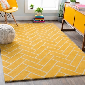 Può includere: Un tappeto rettangolare caratterizzato da uno sfondo giallo vivace con un motivo a spina di pesce bianco ripetuto. Il tappeto ha una consistenza a pelo corto e copre una parte significativa del pavimento, con un design geometrico pulito.
