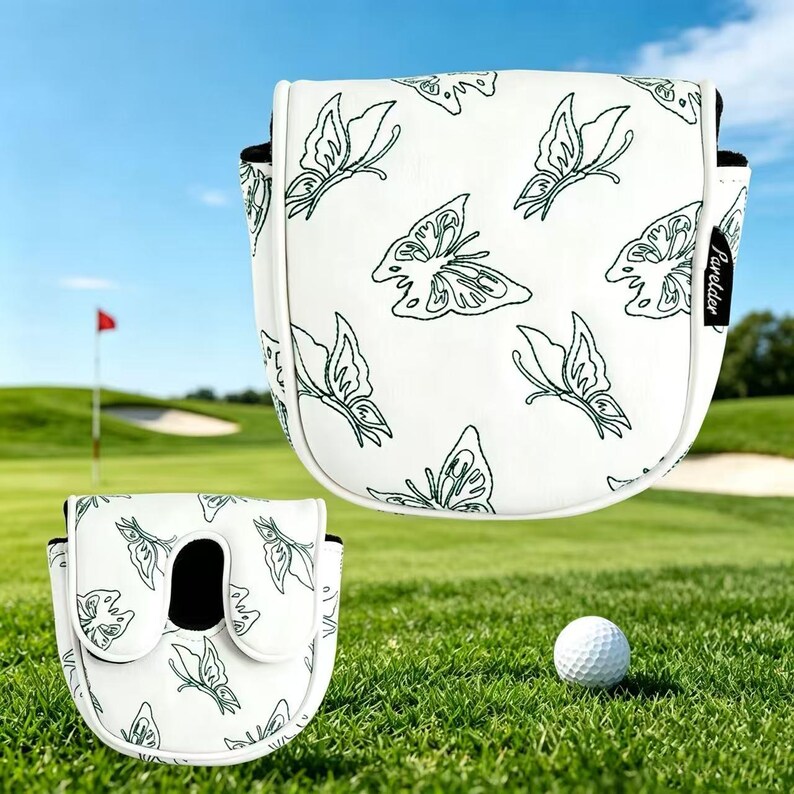 May include: A white golf putter head cover featuring a black butterfly pattern and a small black tag with the text Parelder. The cover has a structured shape with black interior lining and is displayed alongside a white golf ball.