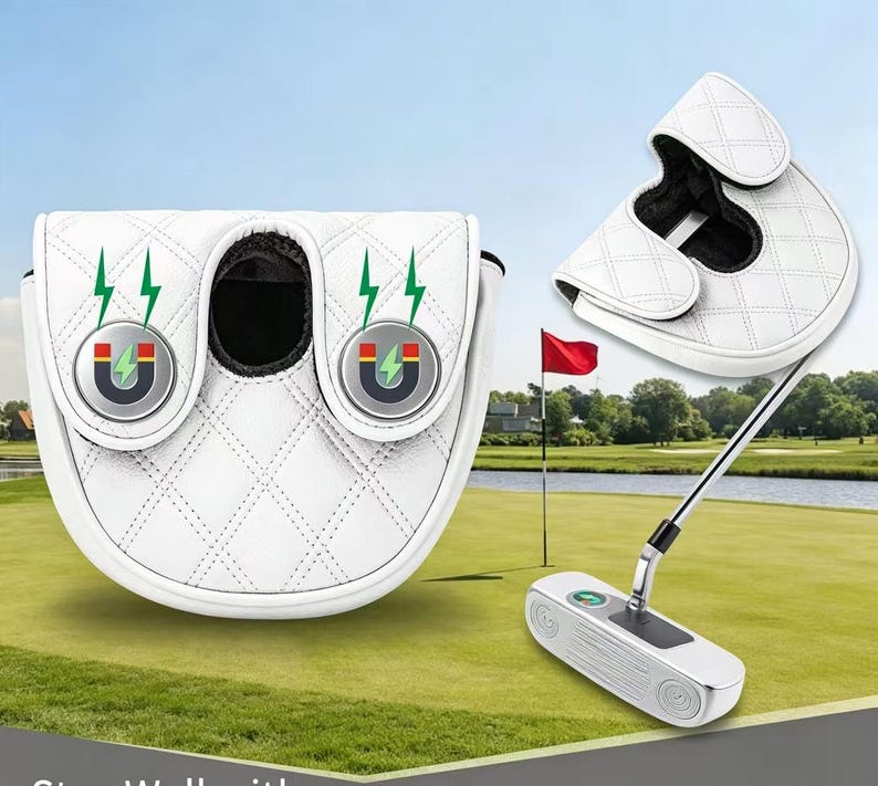 Puede incluir: Una funda blanca para putter de golf con un patr&oacute;n de diamantes acolchado y dos cierres magn&eacute;ticos circulares con iconos de rayos verdes. La funda tiene un forro interior negro y se muestra tanto en posici&oacute;n cerrada como abierta.