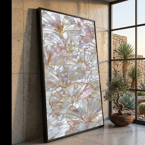 May include: Framed artwork with a repeating pattern of iridescent, fan-shaped designs with gold outlines. The artwork has a black frame and is leaning against a textured wall near a window.