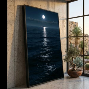 May include: A large rectangular framed wall art piece featuring a dark night seascape with a bright full moon centered in the sky. The moonlight creates a shimmering vertical reflection across the deep blue ocean waves under a thin layer of clouds.