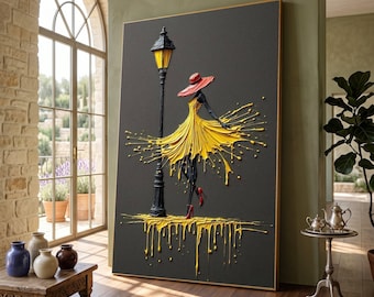 May include: A framed artwork depicts a woman in a yellow dress and red hat, standing near a black lamppost. The artwork features a dark gray background with yellow paint splashes, and is displayed in a room with a large window and wooden floor.