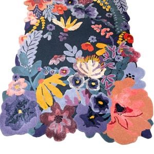 May include: A colourful floral rug featuring a dark blue backdrop and a vibrant arrangement of flowers in purple, orange, yellow, and pink. The rug has an unusual, irregular shape, with the flowers extending beyond the edges.