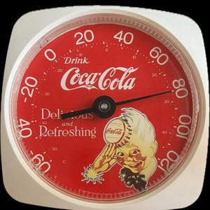 May include: A round Coca-Cola thermometer with a white frame and a red face. The dial features the text Drink Coca-Cola, Delicious and Refreshing, and a graphic of a person holding a bottle cap. It displays temperatures from -60 to 120 degrees Fahrenheit.