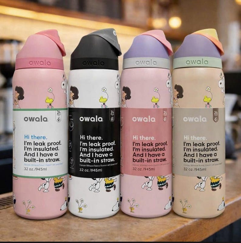 K&ouml;nnte beinhalten: Vier Owala-Isolierflaschen mit unterschiedlich farbigen Deckeln und K&ouml;rpern. Die Flaschen haben einen eingebauten Strohhalm und den Text "Hi there. I'm leak proof. I'm insulated. And I have a built-in straw. 32 oz./945ml".