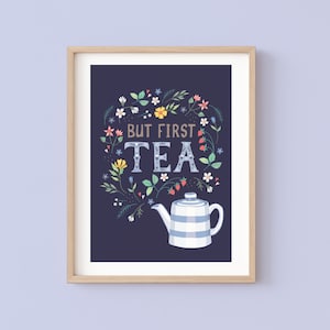 May include: A framed print with a dark blue background featuring a white teapot with blue and white stripes and a floral design with the text "But First Tea".