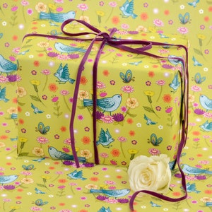 Gelbgrünes Geschenkpapier mit Drosseln und Frühlingsblumen