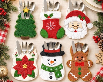 May include: Six fabric cutlery holders shaped like a Christmas tree, stocking, Santa Claus, poinsettia, snowman, and gingerbread person. Each holder contains a silver knife, fork, and spoon. The designs feature embroidered details in red, green, white, and brown.