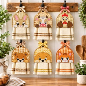 May include: Six hanging kitchen towels with embroidered animal toppers including a rabbit, cow, chicken, bear, dog, and cat. Each towel features a waffle-weave texture, a checkered pattern, and a decorative fabric bow at the top hook.