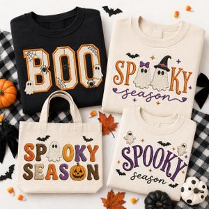 May include: A black sweatshirt with embroidered BOO text, a cream sweatshirt with Spooky season text and ghosts, a cream tote bag with Spooky season text and a pumpkin, and a cream sweatshirt with purple Spooky season text and ghost graphics.