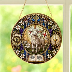 Pode incluir: Vitral redondo com um cordeiro segurando uma bandeira com uma cruz, rodeado por símbolos religiosos e flores. A obra de arte inclui texto da Bíblia. A janela é emoldurada com uma corrente dourada para pendurar.