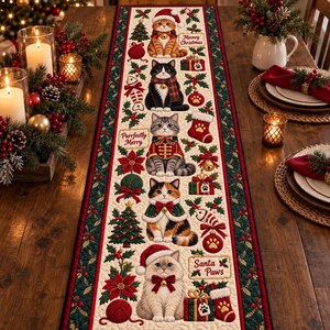 Könnte beinhalten: Ein rechteckiger Tischläufer aus Stoff mit einem cremefarbenen Mittelteil, der fünf Katzen in festlicher Kleidung, Weihnachtsbäume, Geschenke, Strümpfe und Wollknäuel zeigt, umrandet von einem dunkelgrünen Band mit roten Stechpalmenbeeren.