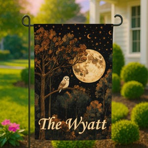 Puede incluir: Una bandera de jardín rectangular que muestra una escena de bosque nocturno con una gran luna llena, un búho posado y un cielo estrellado. El texto The Wyatt está impreso en una fuente serif color crema claro en la parte inferior.
