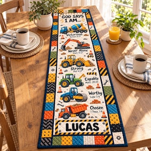 May include: A rectangular table runner featuring a construction theme with illustrations of a cement mixer, excavator, tractor, and dump truck. The text reads GOD SAYS I AM, VICTORIOUS, NEVER ALONE, STRONG, CAPABLE, WORTHY, CHOSEN, and LUCAS.