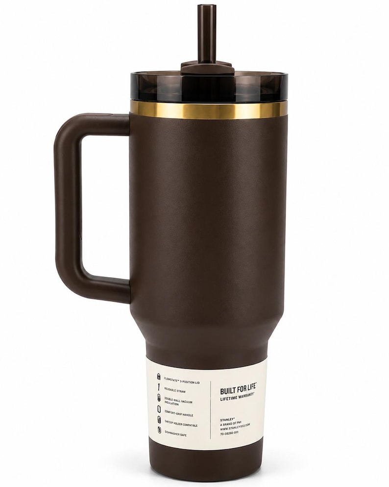 K&ouml;nnte beinhalten: Ein brauner isolierter Becher mit Griff und Strohhalm. Der Becher hat einen schwarzen Deckel mit einem goldfarbenen Band. Ein wei&szlig;es Etikett an der Seite lautet "Built for Life" und listet Funktionen auf. Der Becher ist f&uuml;r Getr&auml;nkehalter im Auto geeignet.