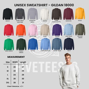 May include: A display of Gildan 18000 unisex sweatshirts in various colors, including black, red, and navy. The image also shows a size chart with measurements in inches for sizes S through 2XL. A person is wearing a white sweatshirt.