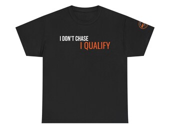 May include: A black short-sleeved t-shirt featuring the white text I DON'T CHASE and the orange text I QUALIFY printed on the chest. A small circular orange and black logo is visible on the upper right sleeve area of the garment.