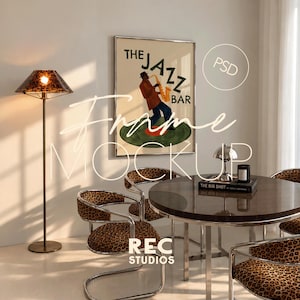 May include: A framed poster titled THE JAZZ BAR featuring a musician playing a saxophone, displayed in a room with a floor lamp, a round table with a chrome base, and chairs upholstered in a brown and black leopard print fabric pattern.