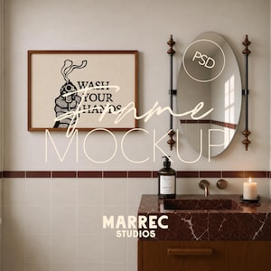 May include: A rectangular wooden frame containing a print with a black graphic of a hand holding a smoking gun and the text WASH YOUR HANDS. Next to it is an oval mirror with dark brown decorative posts, a soap dispenser, and a white candle.