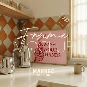 May include: A kitchen scene featuring a framed pink print with the words "WASH YOUR HANDS" in red. A chrome toaster and kettle sit on the counter, along with a beige mug. The background includes a tiled backsplash and a wooden shelf.