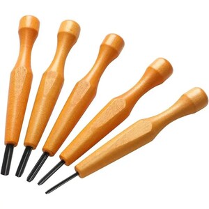 May include: A set of five carving tools with light brown wooden handles and black metal tips. Each tool features a smooth, contoured handle that tapers toward a sharp, pointed or flat metal blade, arranged in a diagonal row against a white background.