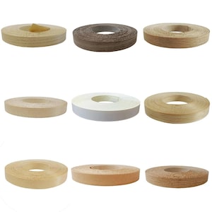 May include: A collection of nine circular rolls of wood veneer edge banding tape, displayed in a grid. The rolls feature various wood grain patterns and colors, including light beige, medium brown, dark brown, and a solid white finish.