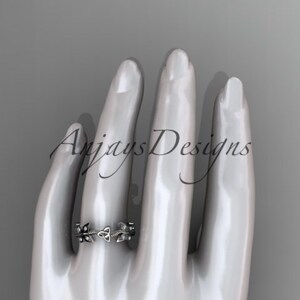 Puede incluir: Un anillo de plata con un dise&ntilde;o de nudo celta. El anillo est&aacute; en el dedo de una mano de maniqu&iacute;.