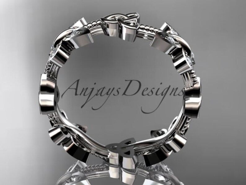 Puede incluir: Un anillo de plata con un dise&ntilde;o de nudo celta y peque&ntilde;os diamantes. El anillo est&aacute; engastado con un diamante m&aacute;s grande en el centro del nudo.