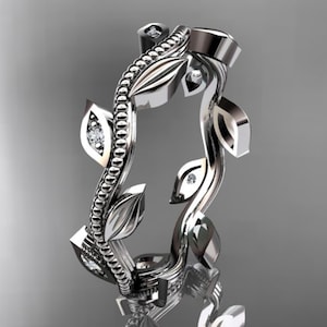 May include: A silver ring with a vine design and small clear stones. The vine is made of a twisted metal band with leaves and small stones.