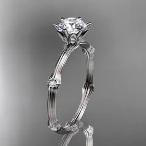 May include: A silver engagement ring with a large, round, clear diamond set in a flower-shaped setting. The band is made of twisted metal and has smaller diamonds set into the band.